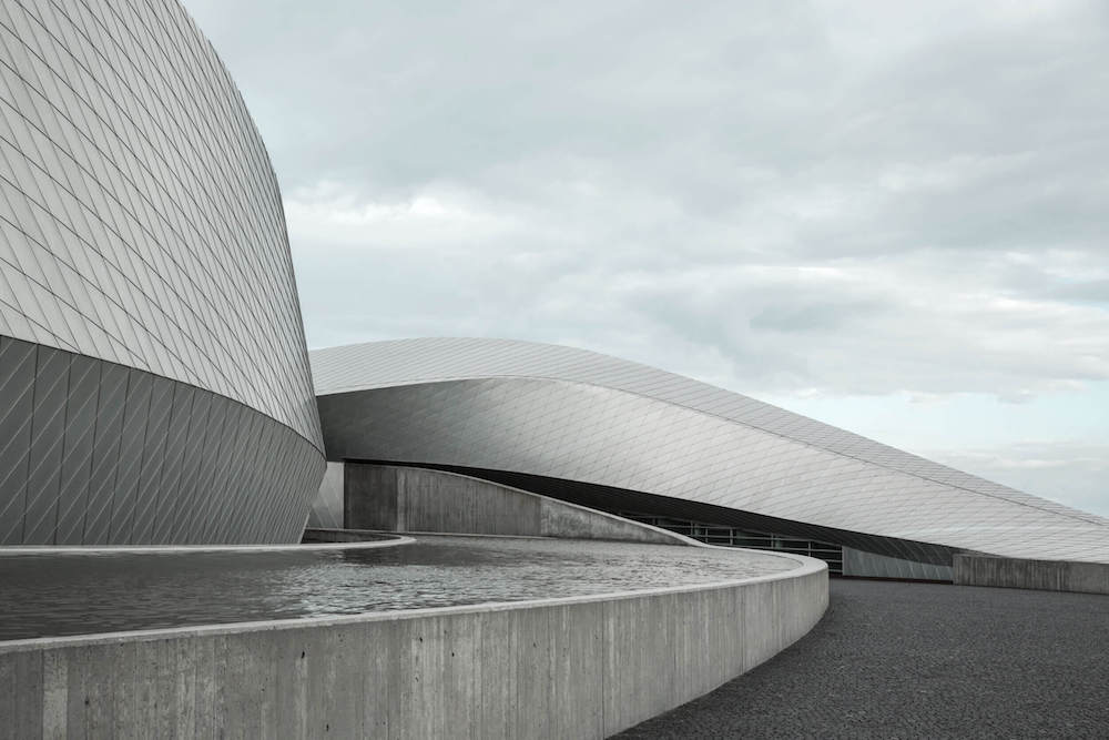 Curved building with an artificial pond.