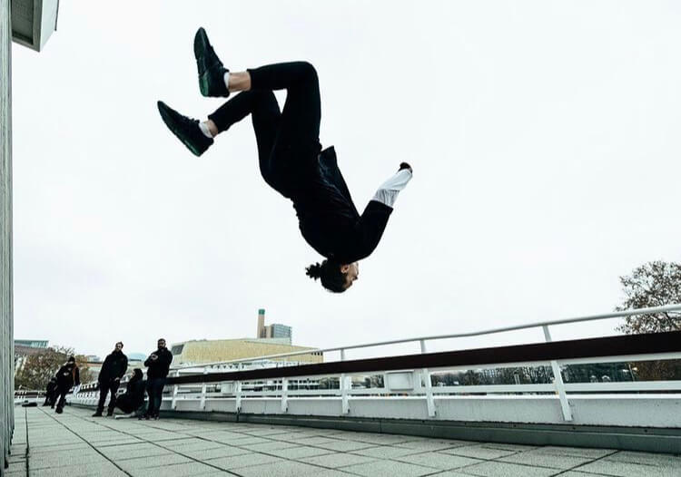 An urban dancer doing a parkour jump.