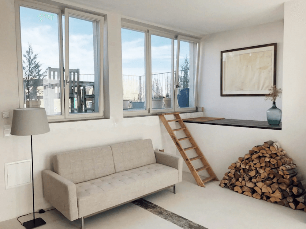 Artist loft living room with fireplace available for rent for your next film production in Berlin, Germany. Minimalist and unique interior design