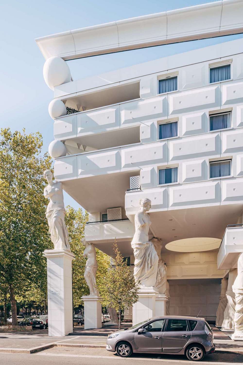 Facade of a white Romanesque building, with sculptural columns.