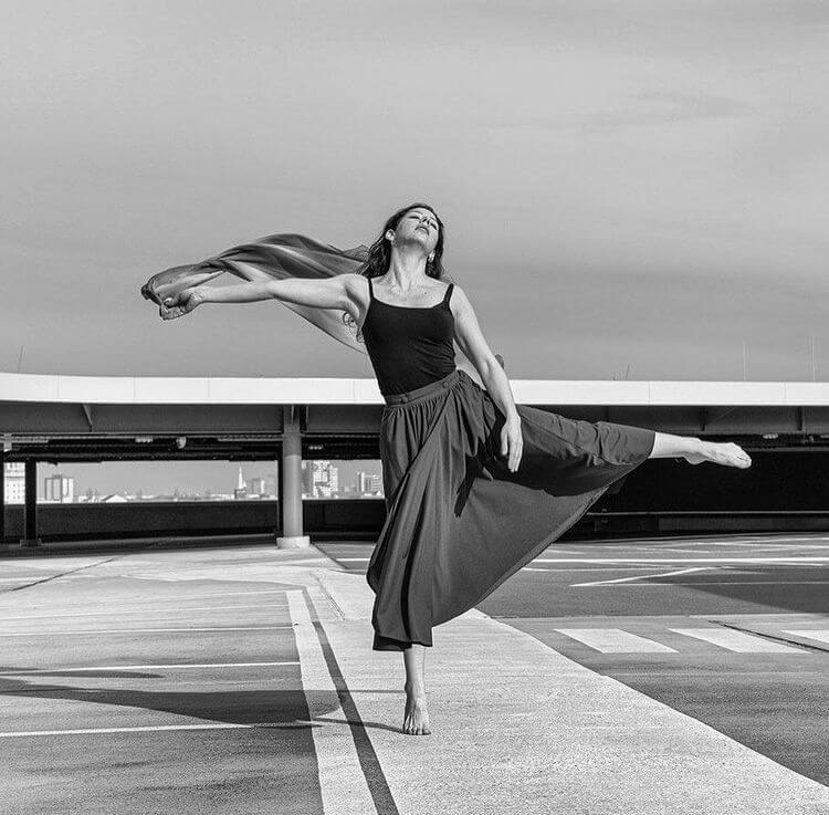 A dancer in motion in an empty car park.