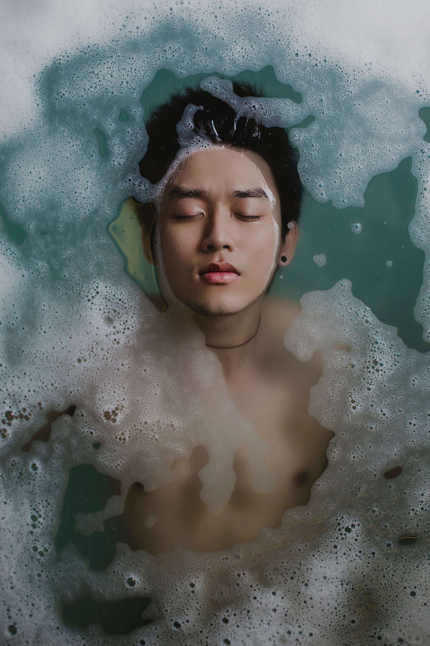 A young man in a foaming bath.