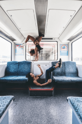 Two girls dancing and doing acrobatics inside the Sbahn.