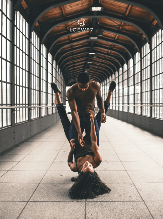 A couple dancing in a train station.