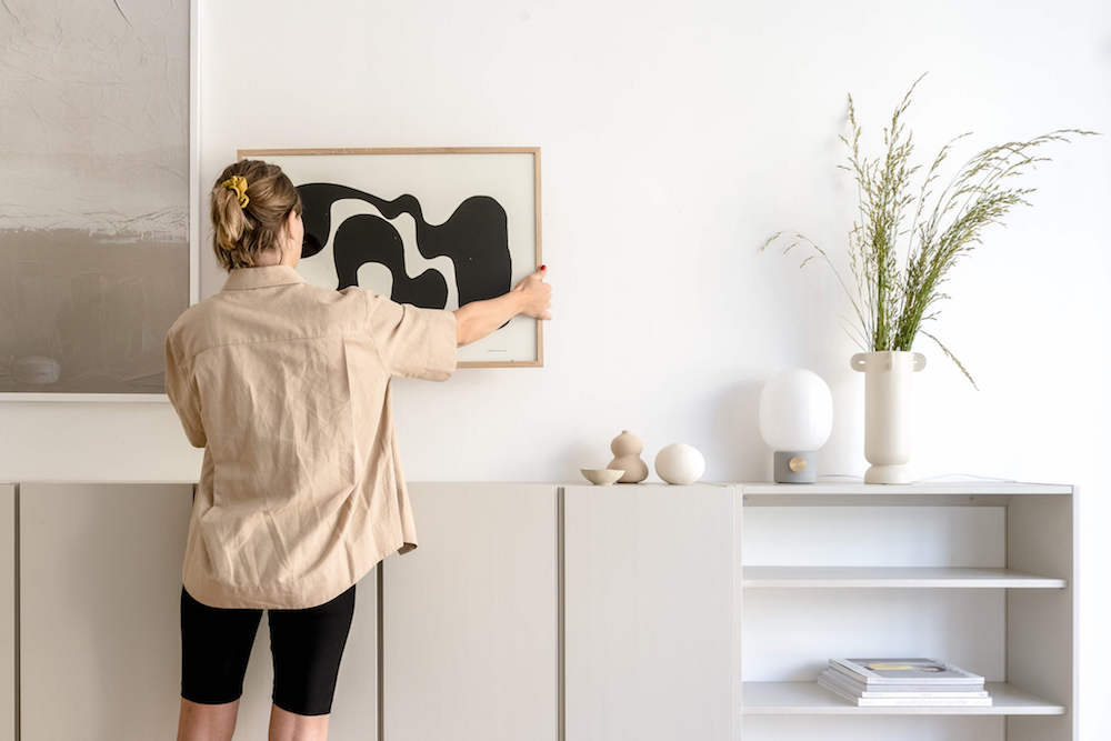 Set designer placing a drawing on the wall for the next photoshoot.