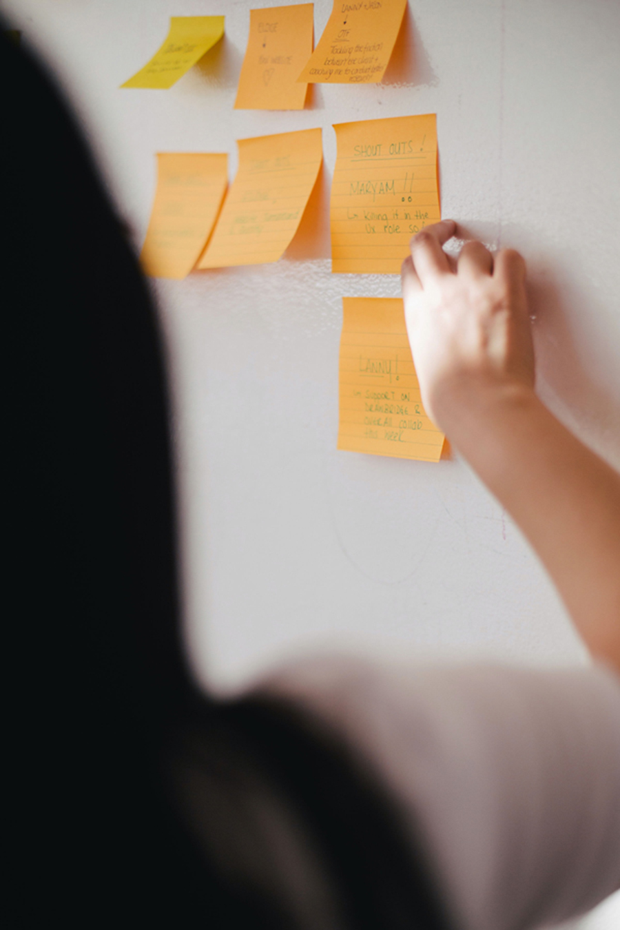 Behind woman posting notes on the board