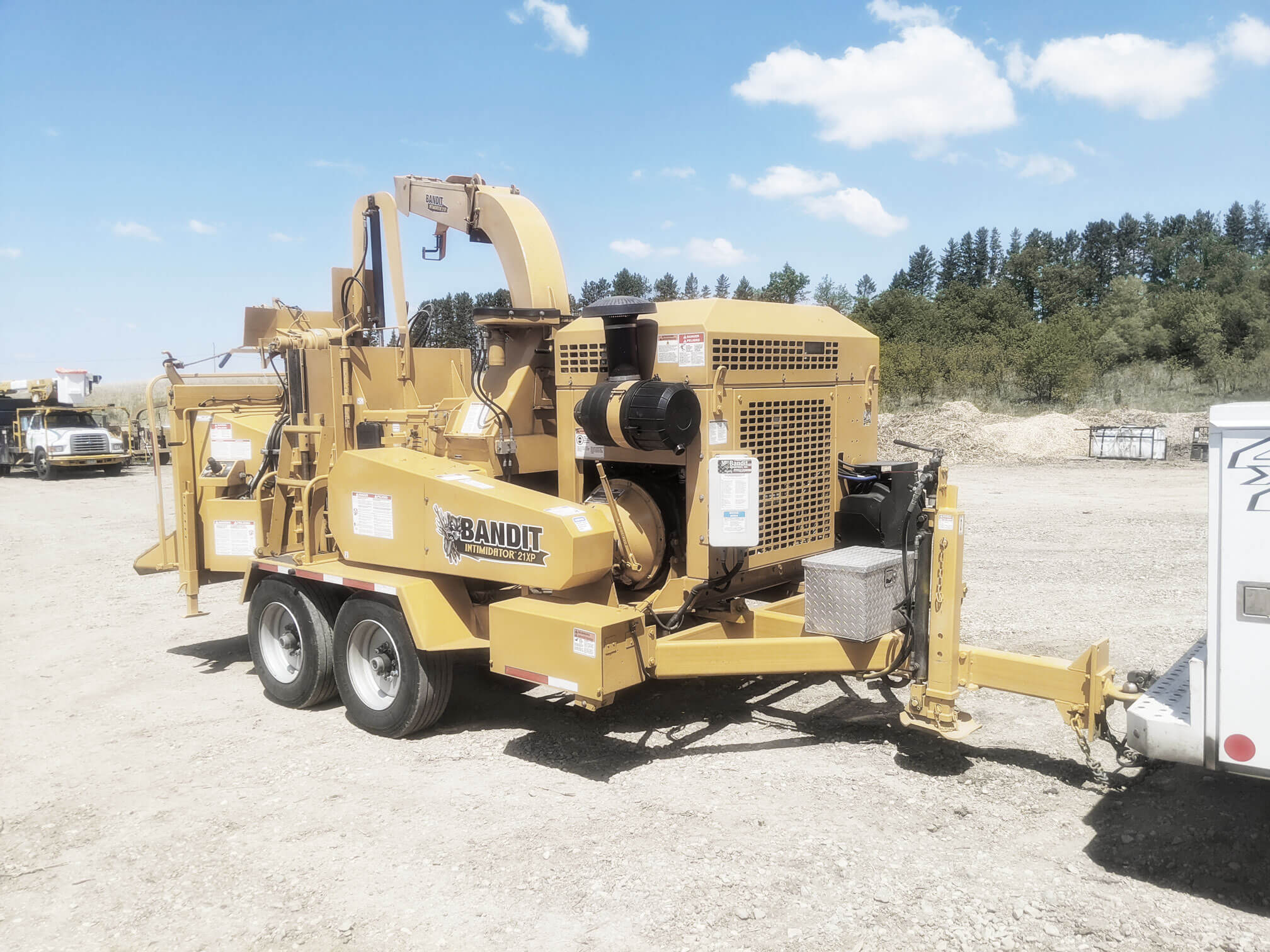 Yellow Bandit 21 XP Wood Chipper parked on gravel lot. Commercial tree equipment that allows for quick, easy removal of trees