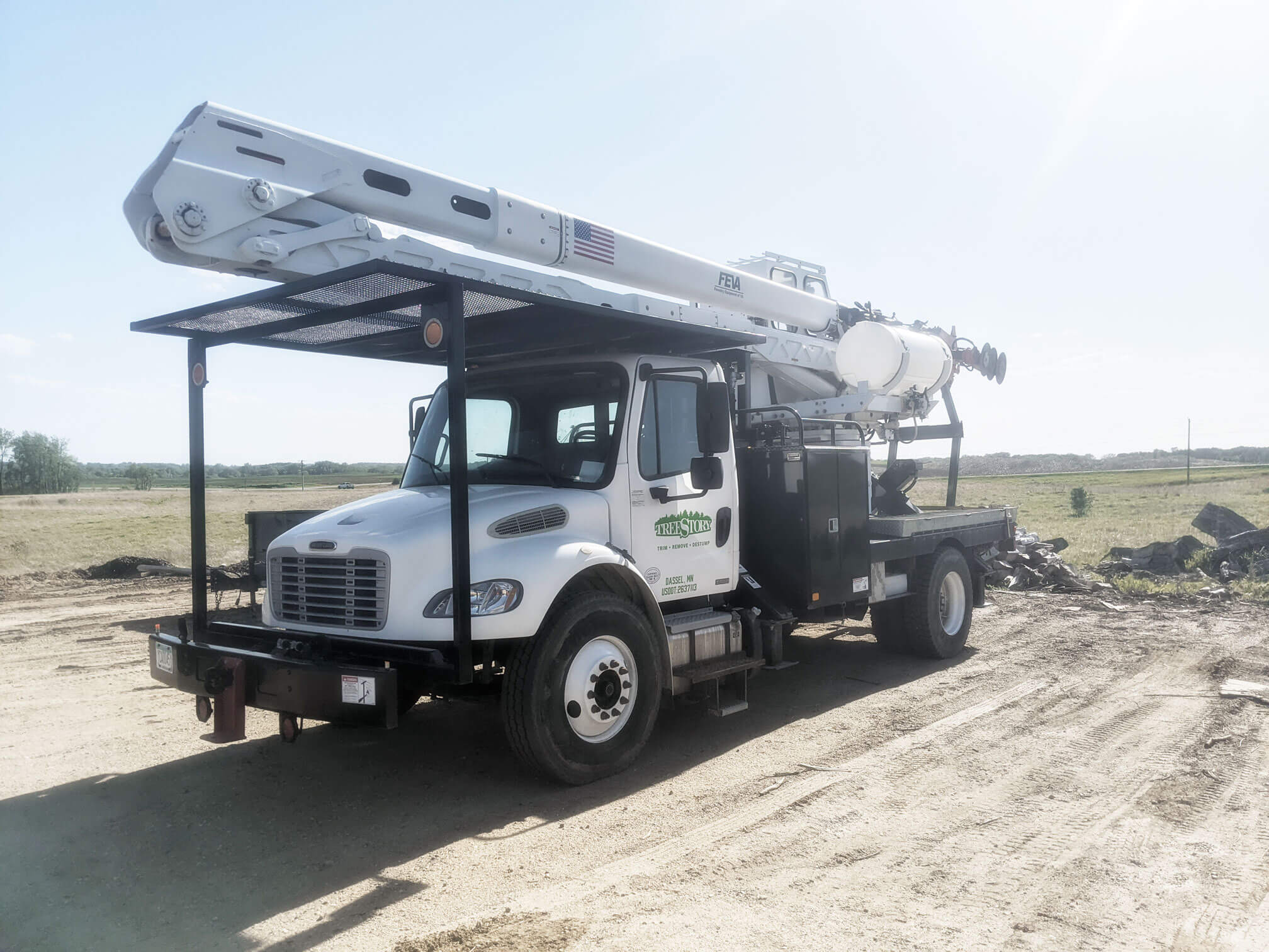 Terra Tech Treemaster truck in white sitting on an empty gravel lot. Commercial heavy-duty machinery for tree maintenance