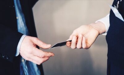 Two people exchange business cards at a chamber of commerce meeting. nonprofit consulting palm desert ca