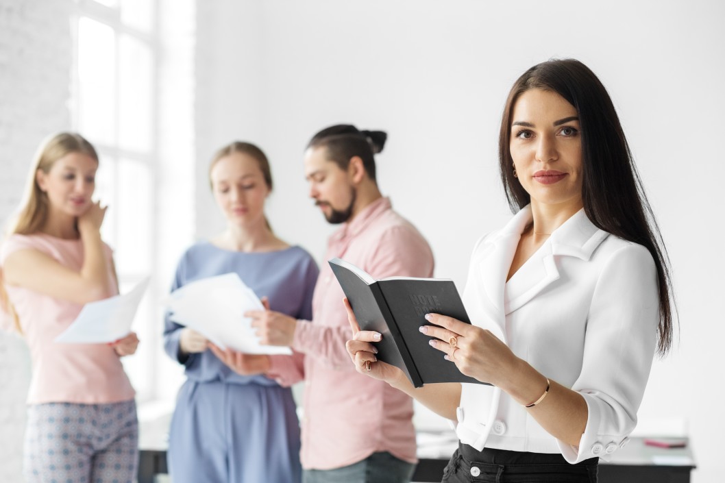 executive advisor nonprofit employee handbook. Three are in the background; one woman with long, dark hair is in focus in the foreground.