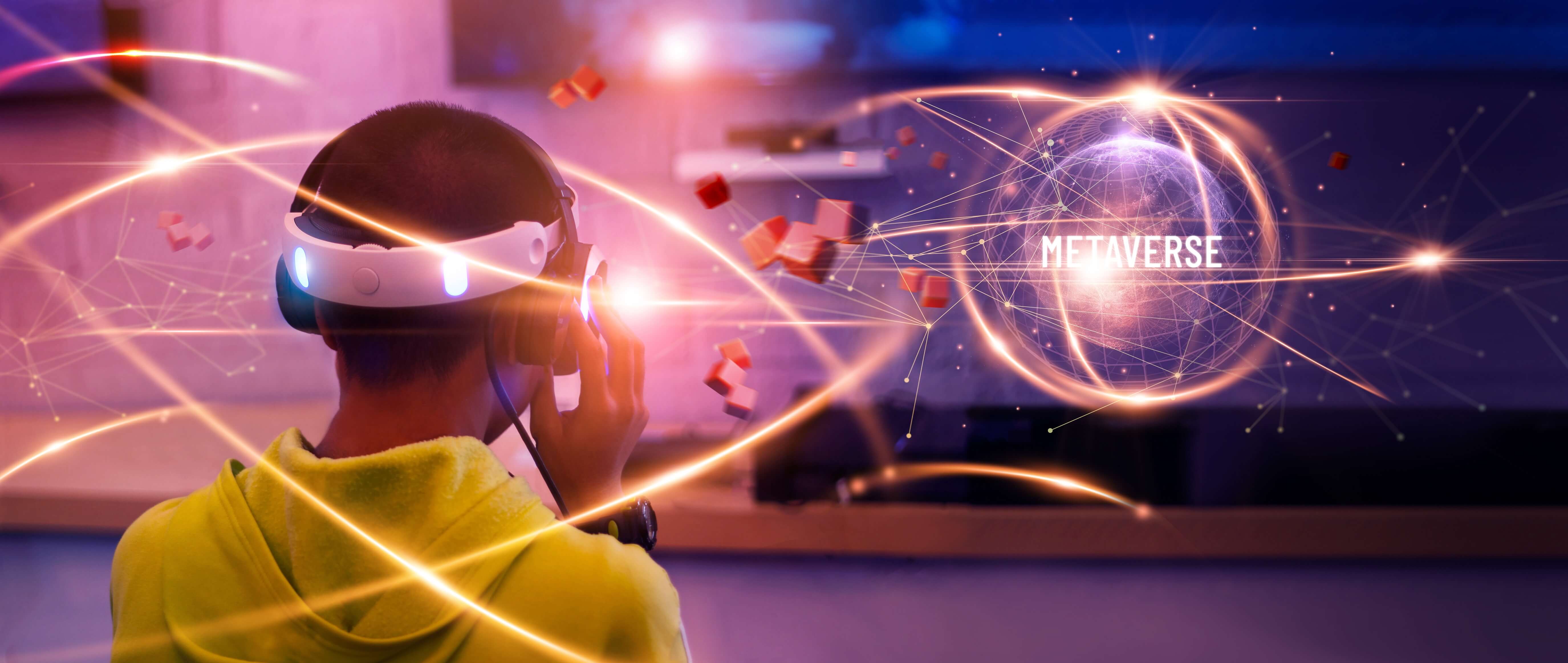 A person wearing a VR headset. In front of them is a glowing graphic that reads 'metaverse'.