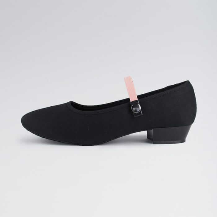 A black junior character shoe with pink strap detail