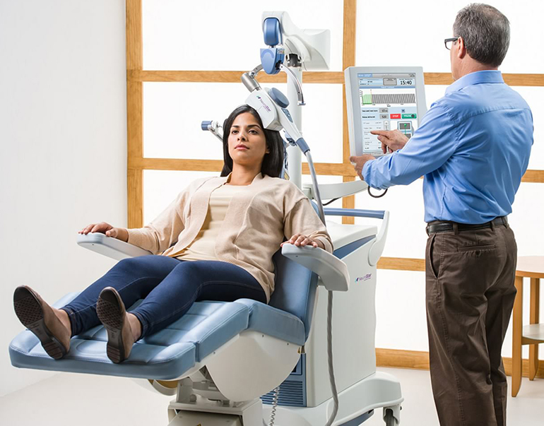 Technician administers TMS using Neurostar TMS Machine