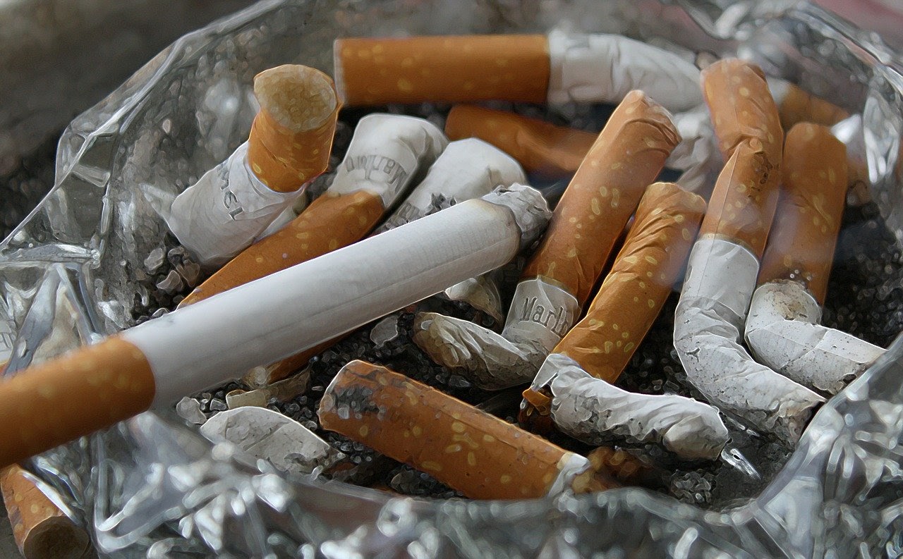 A pile of smoked cigarettes sit in an ash tray.