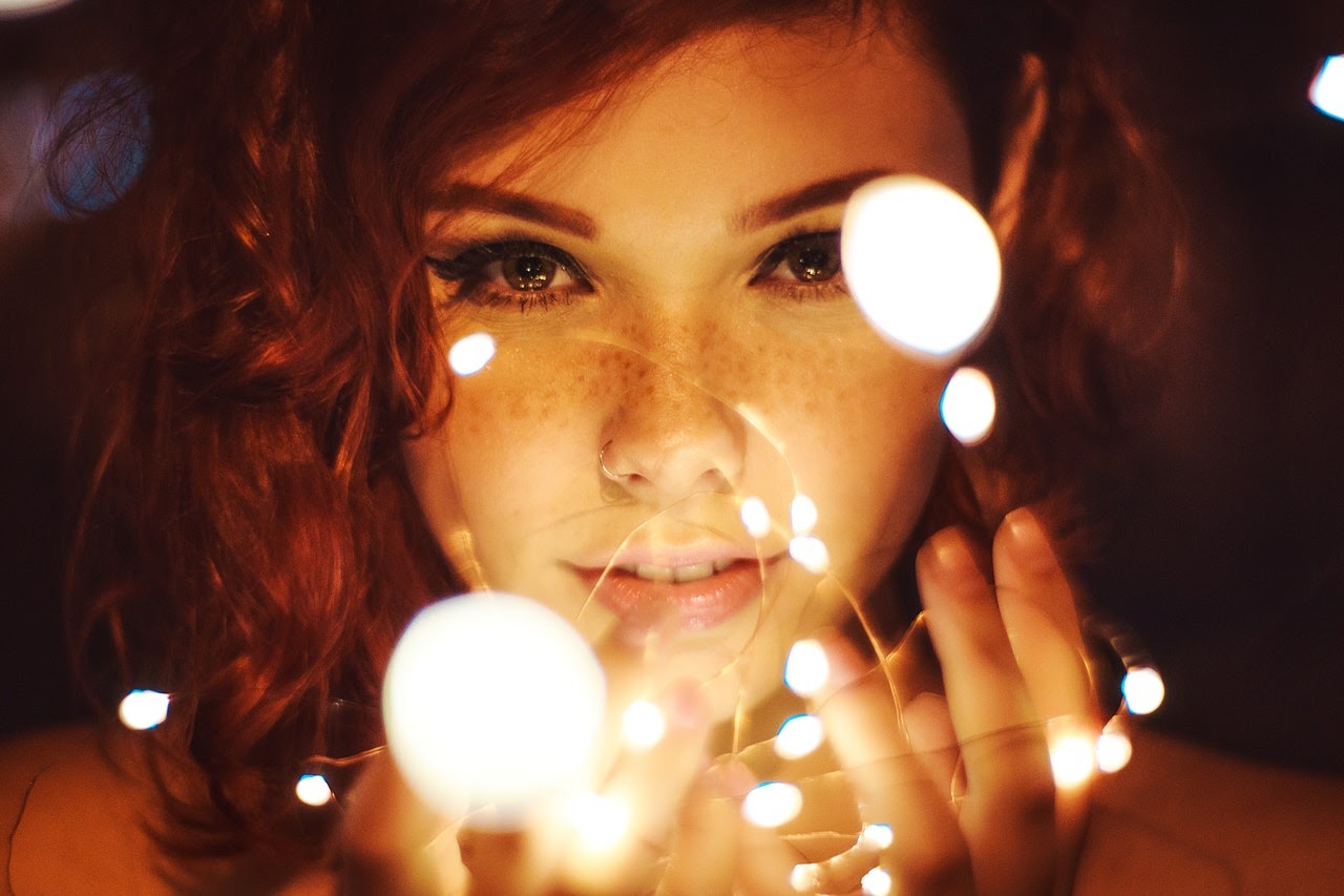 Woman holds string lights in her hands