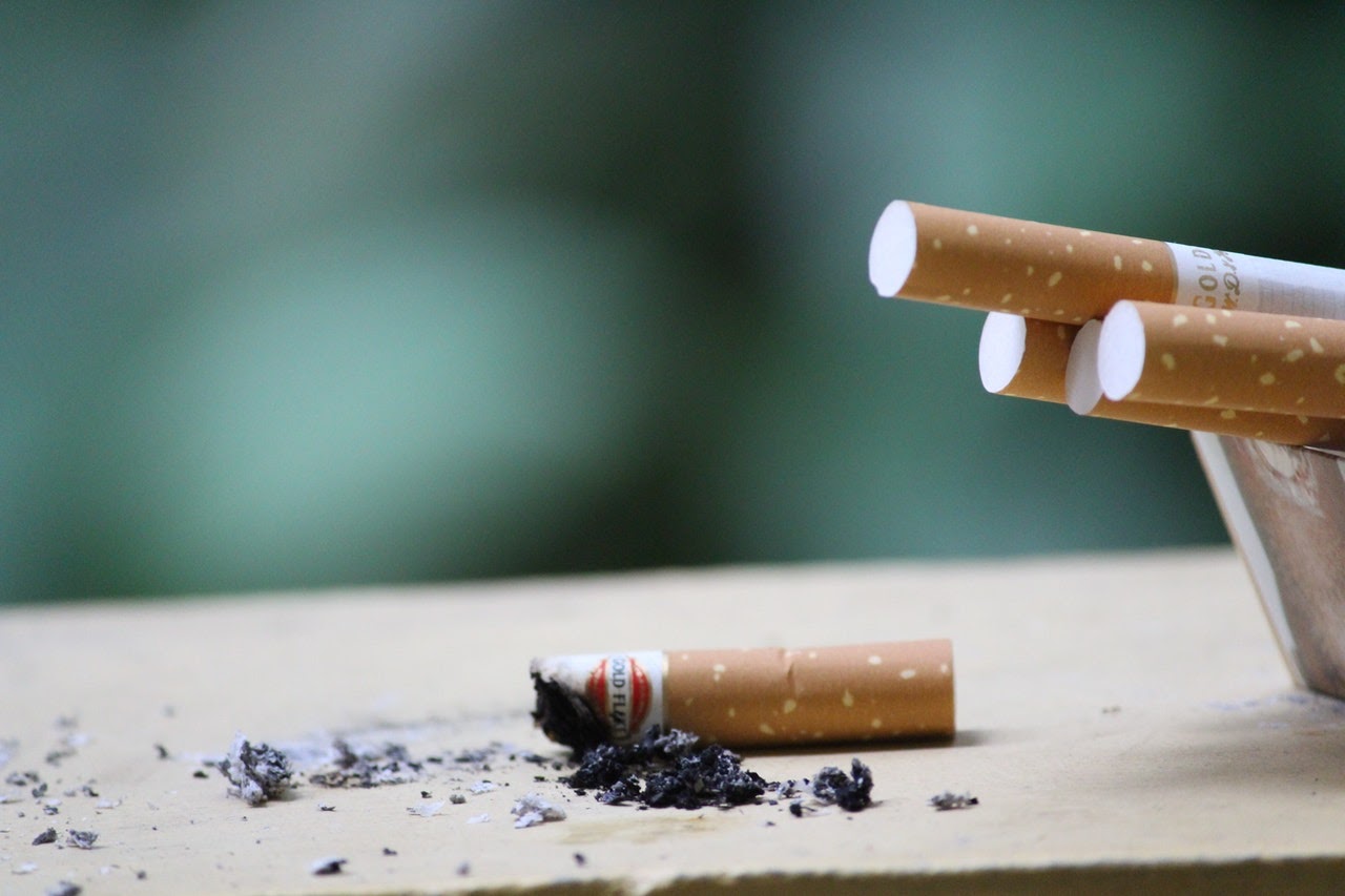 A handful of cigarettes sit on a table.
