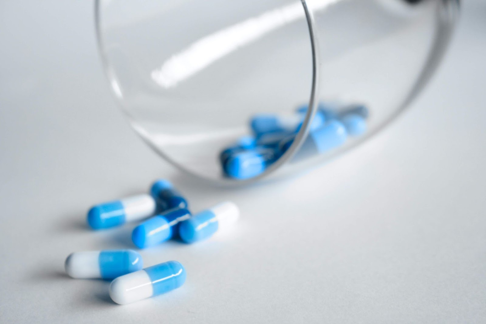 Blue and white pills on a white table
