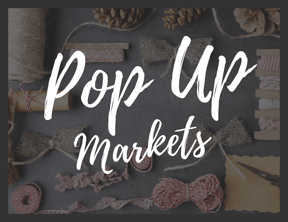 Pop Up Markets in handwriting font with craft supplies in the background
