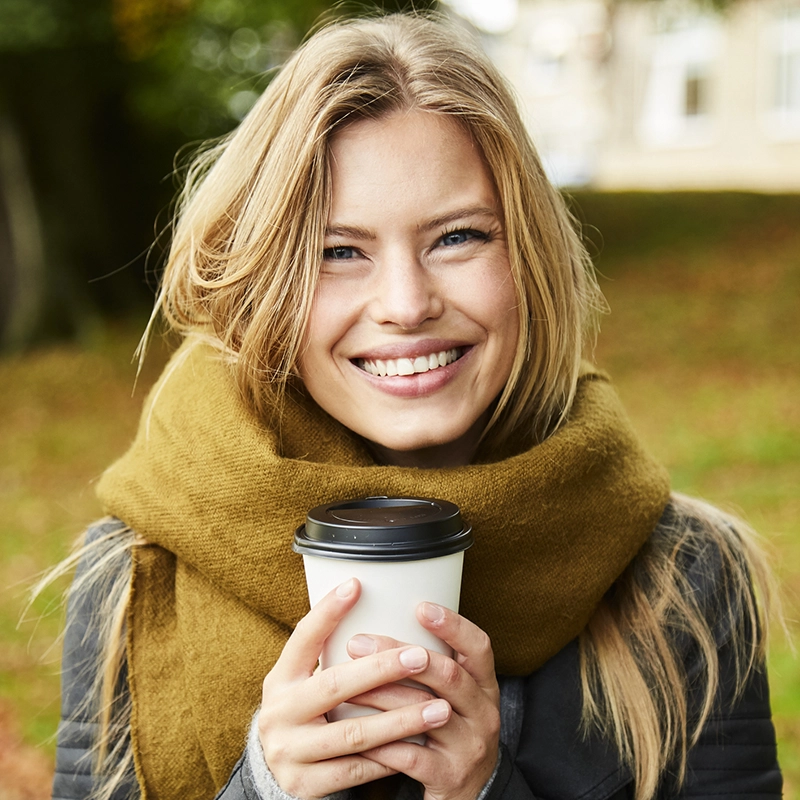 Beautiful woman in the fall holding a coffee cup