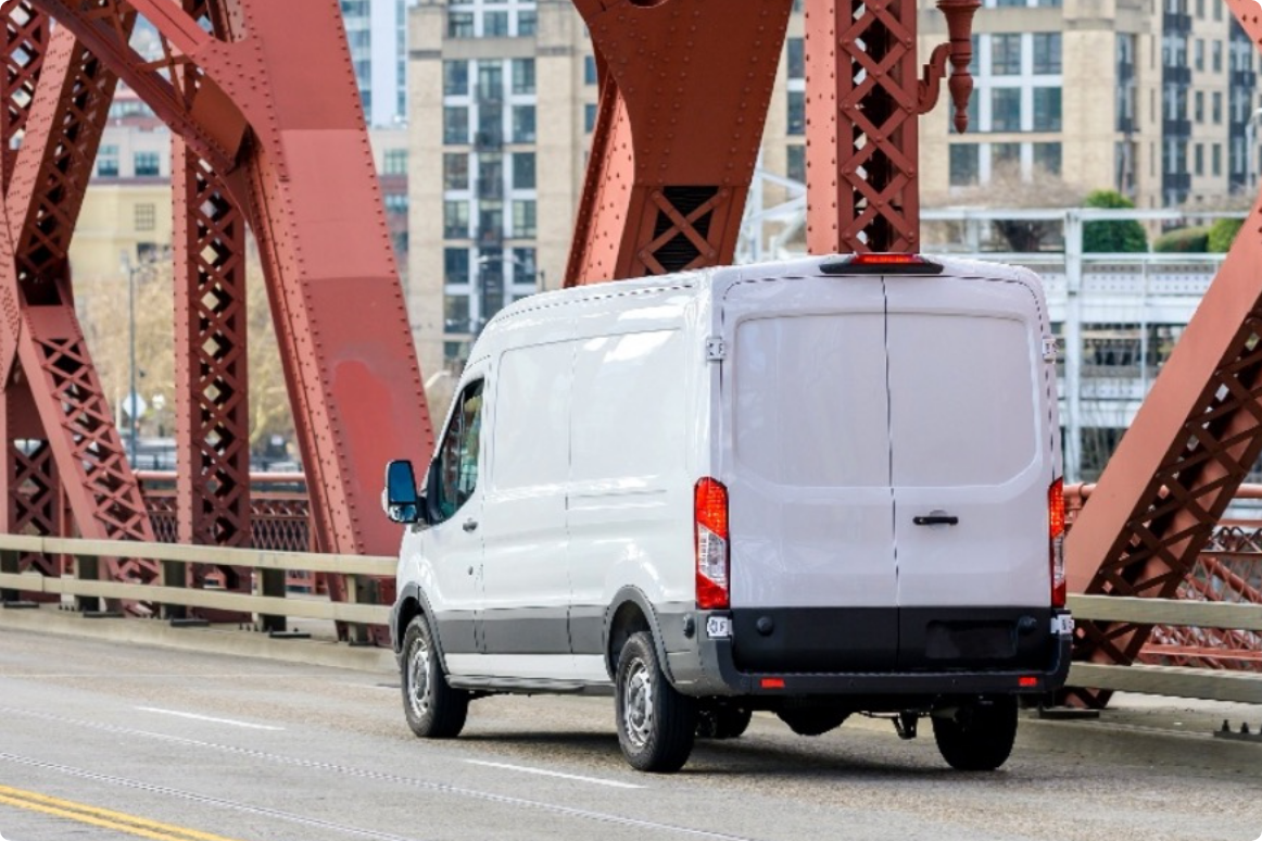 a transit van driving over a red bridge