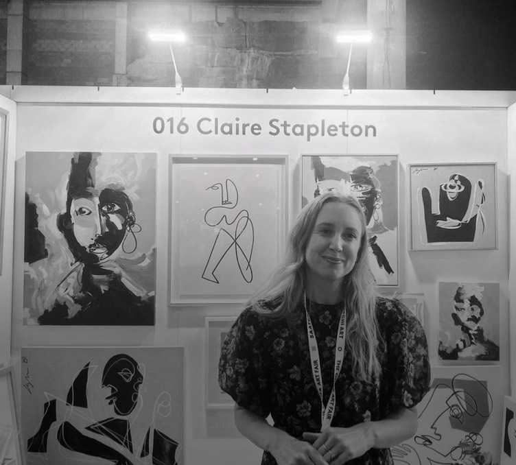 A Works staff member standing in front of her artworks
