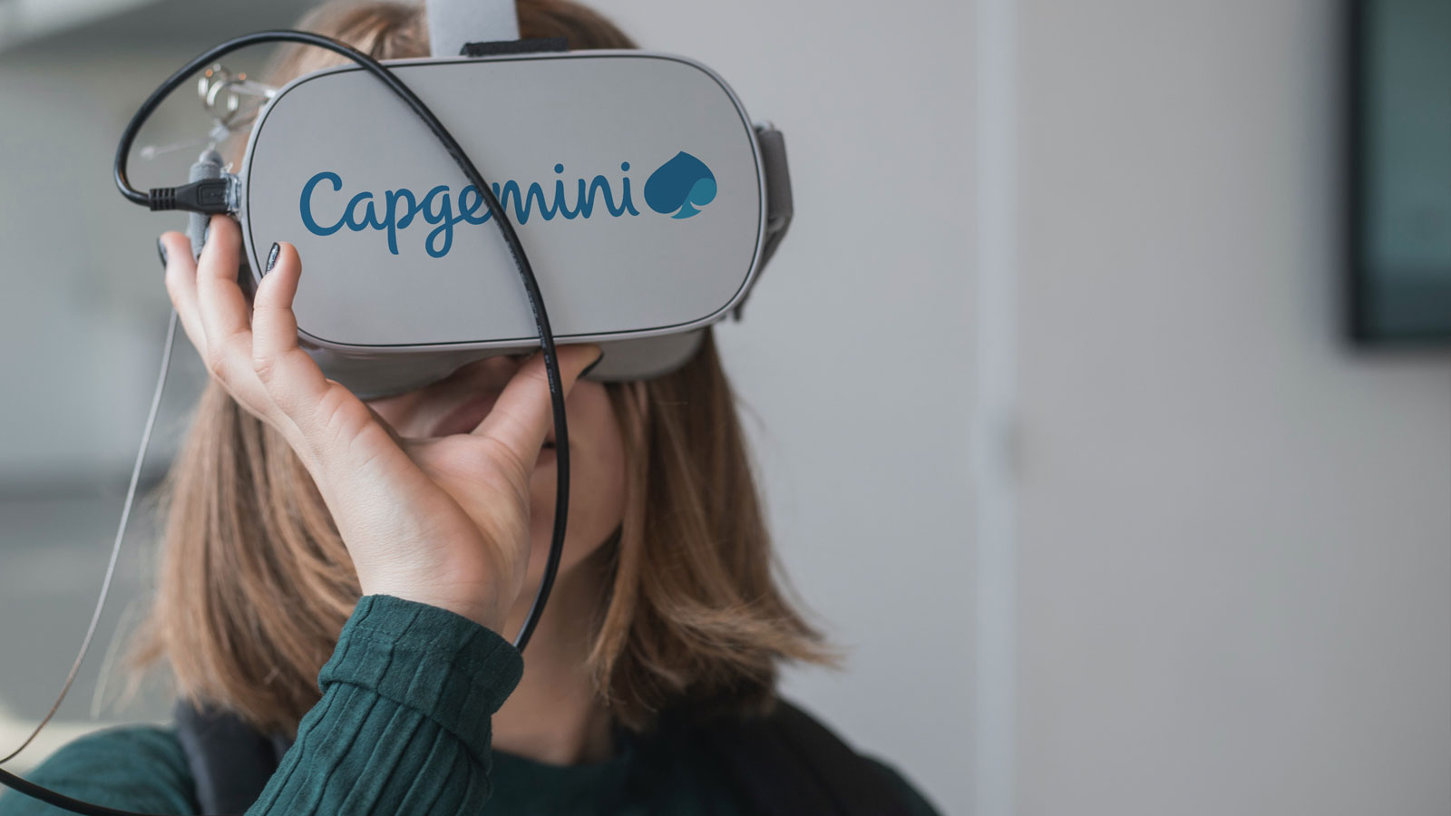 Lady using a VR headset with a Capgemini logo on it