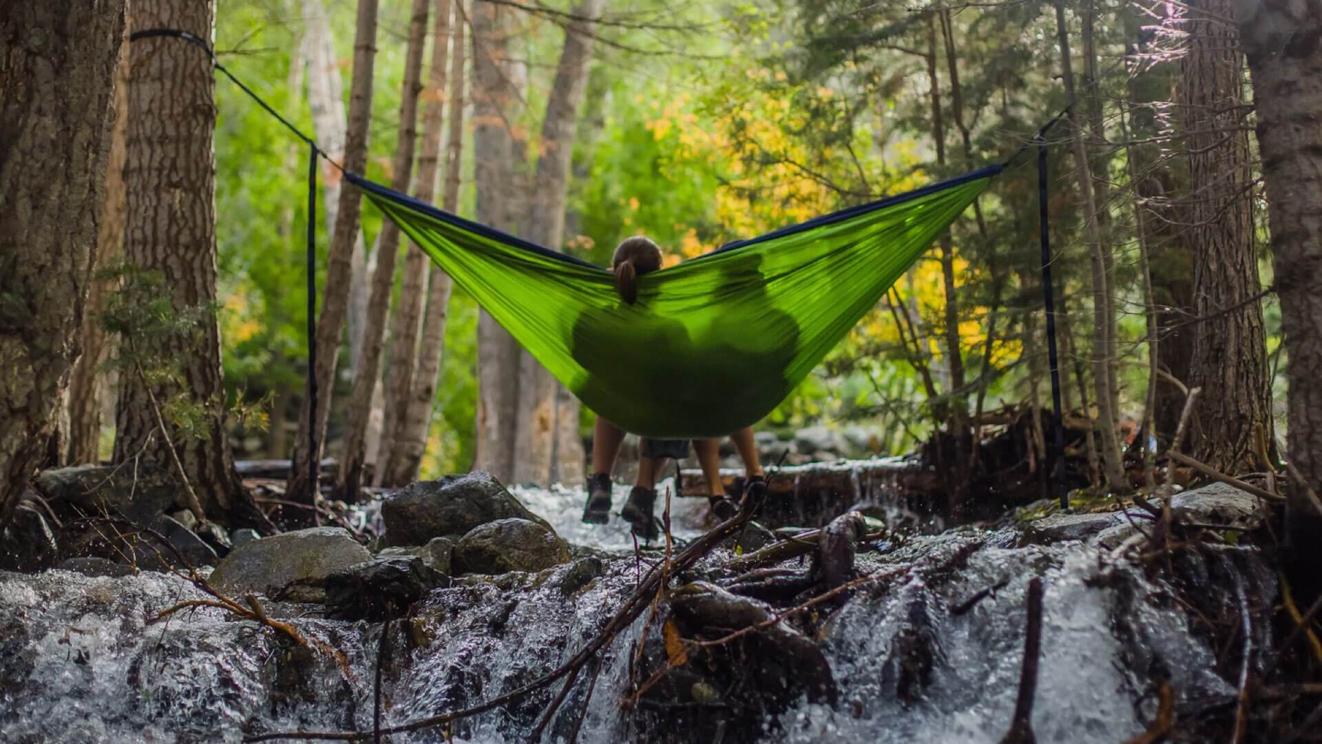 Digital Detoxing; Two people sitting in a hammock in the wilderness