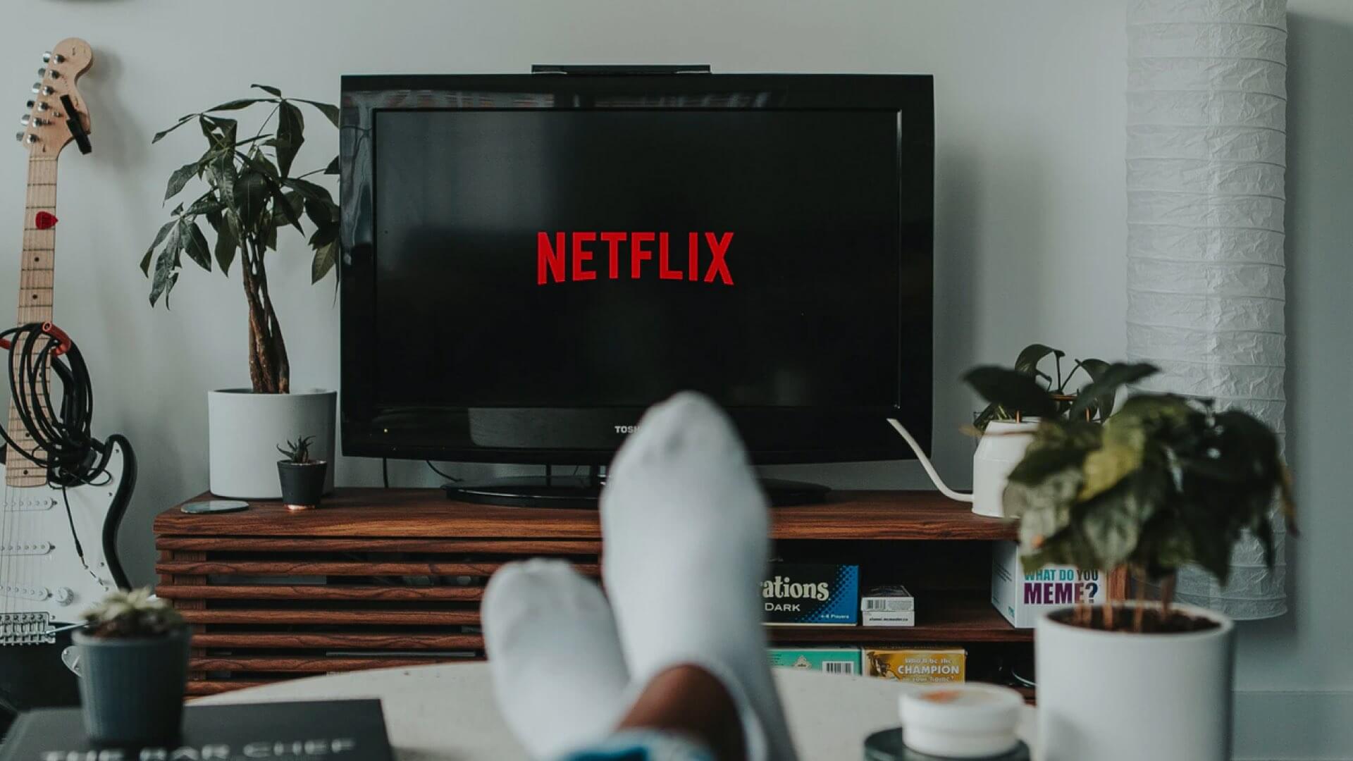 Person with feet up streaming Netflix on their TV