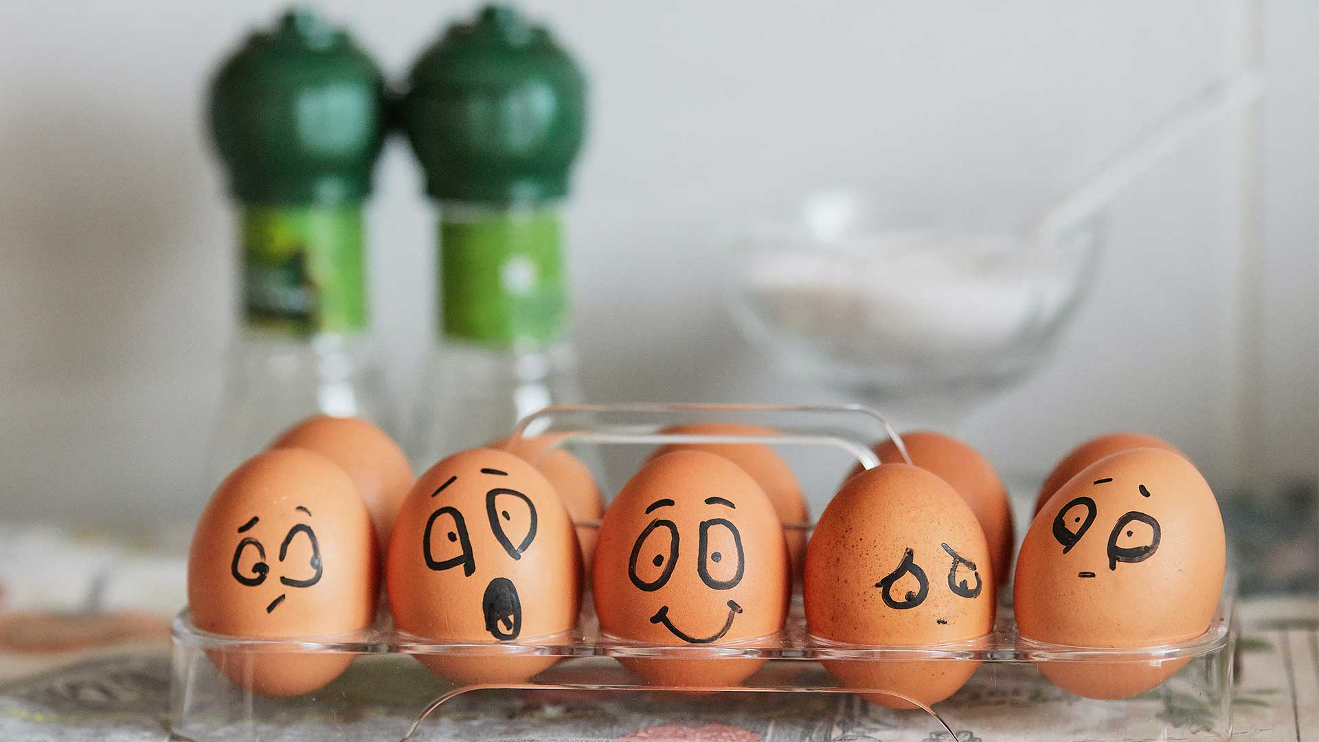 Eggs with various facial expressions drawn on them with a marker