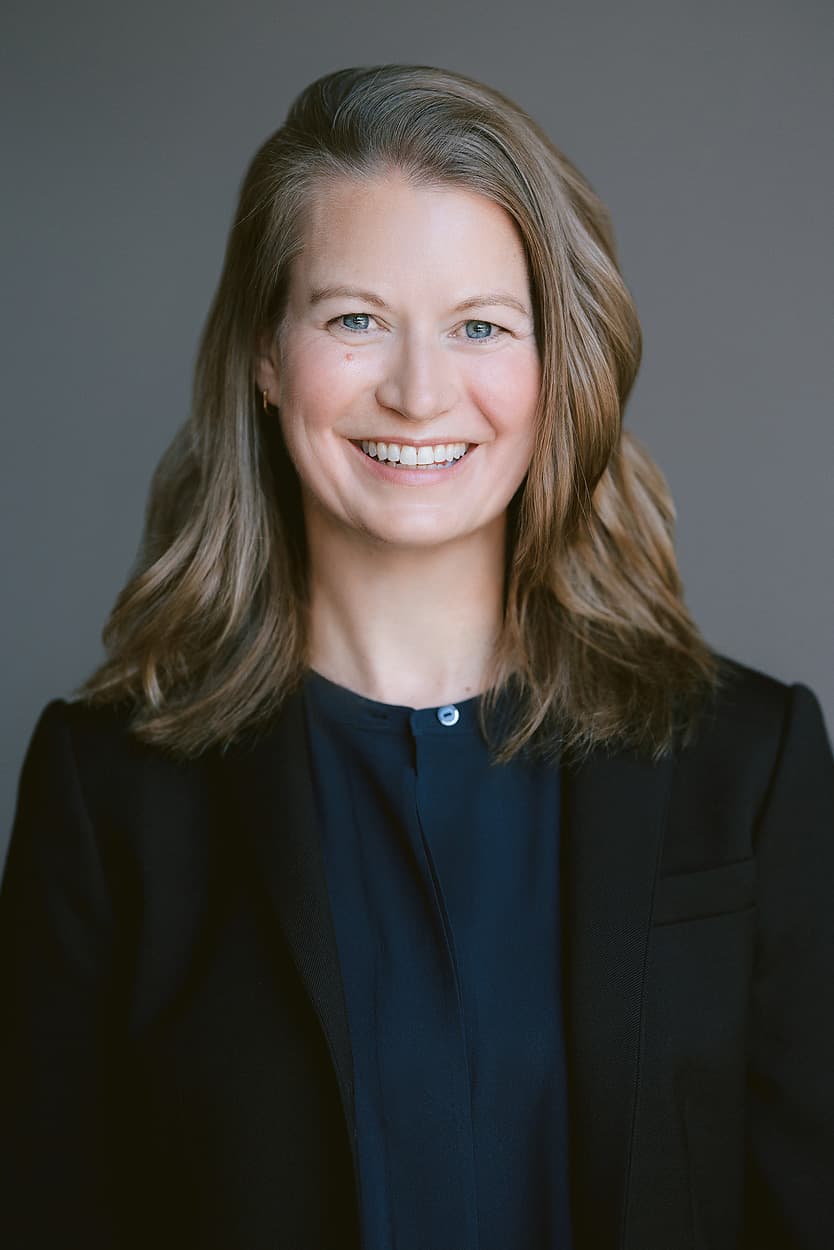 Portrait of Carla Fowler. Smiling woman with blonde hair and a black blazer.