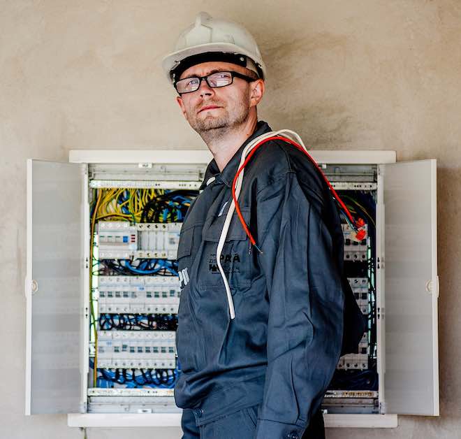 an electrician at a circuit breaker box