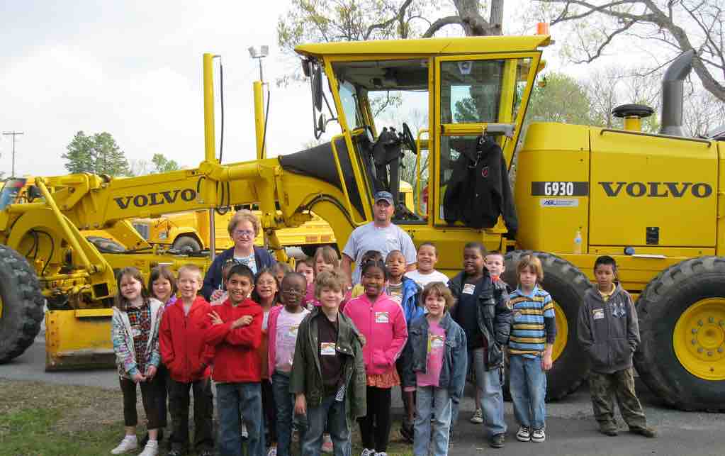 Schoolkids in front of heavy construction equipment