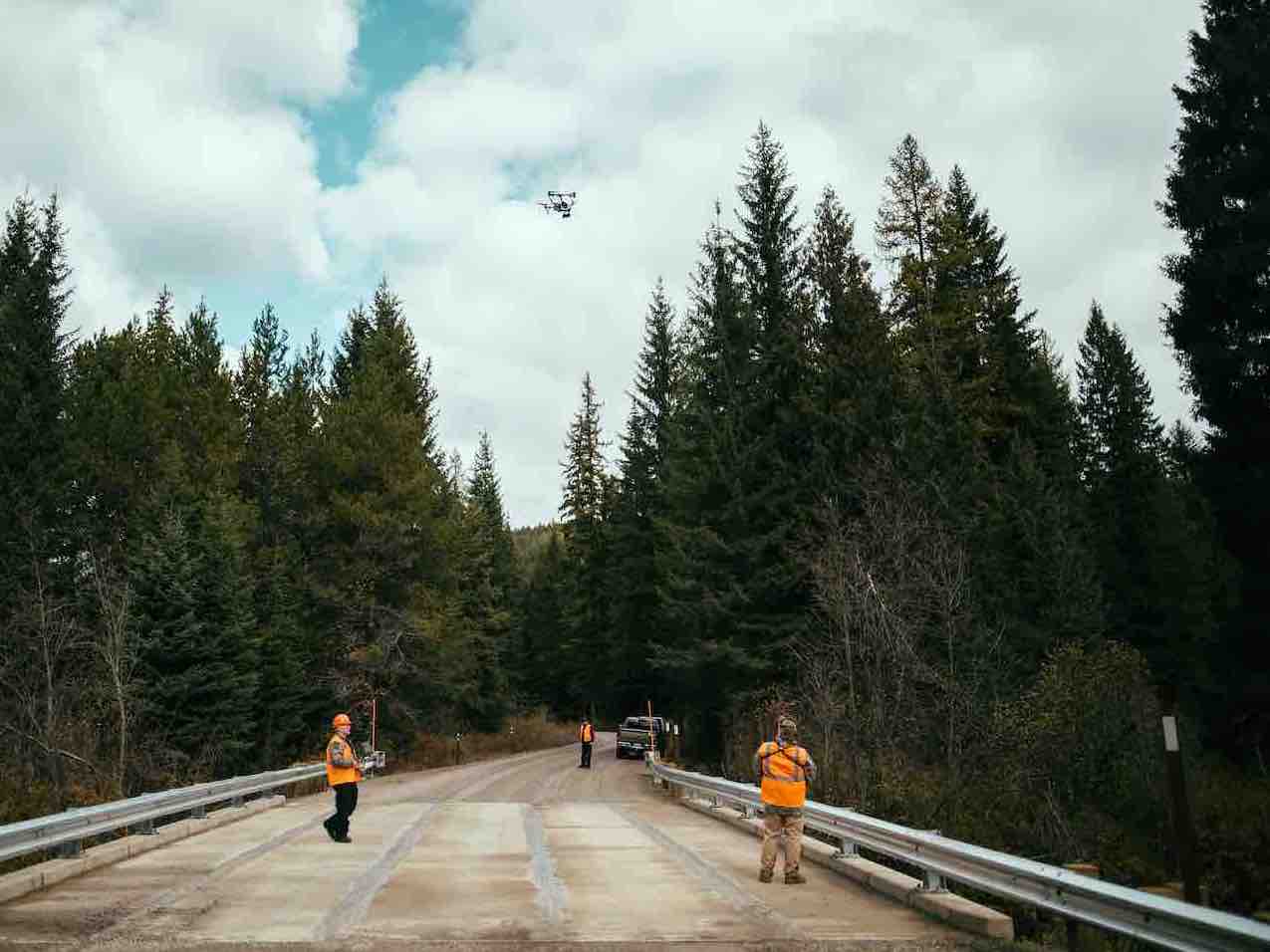 construction crew flying drone on bridge