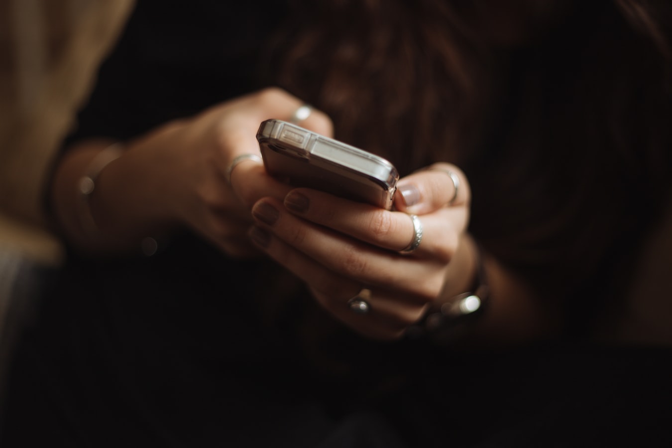 A woman typing into a cell phone