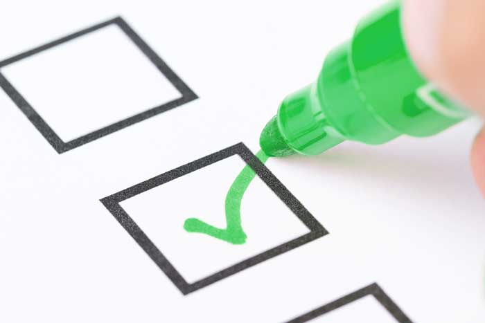 a compliance box being checked off by a green pen