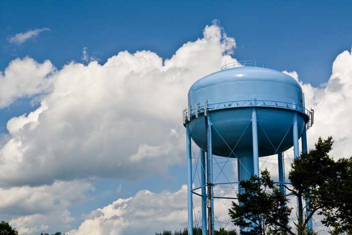 a blue water tower against a cloudy sky