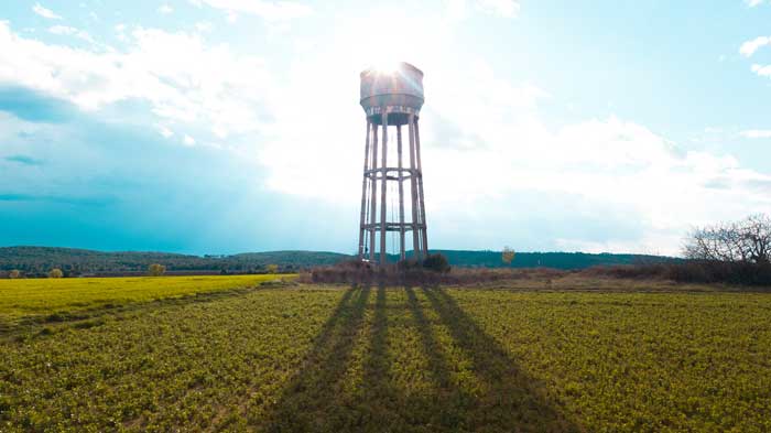 a water tower in a field