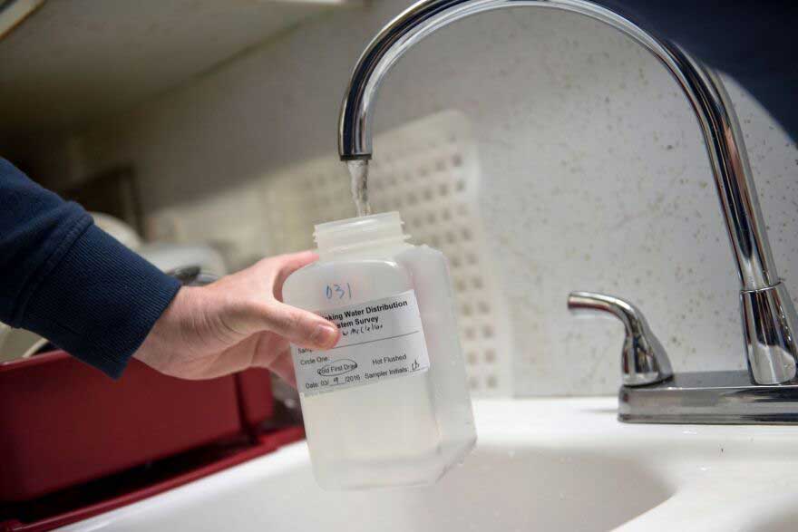 a water sampling bottle being filled at the tap