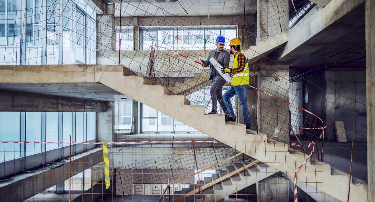 An owner visits a construction site for an in-person construction progress report.