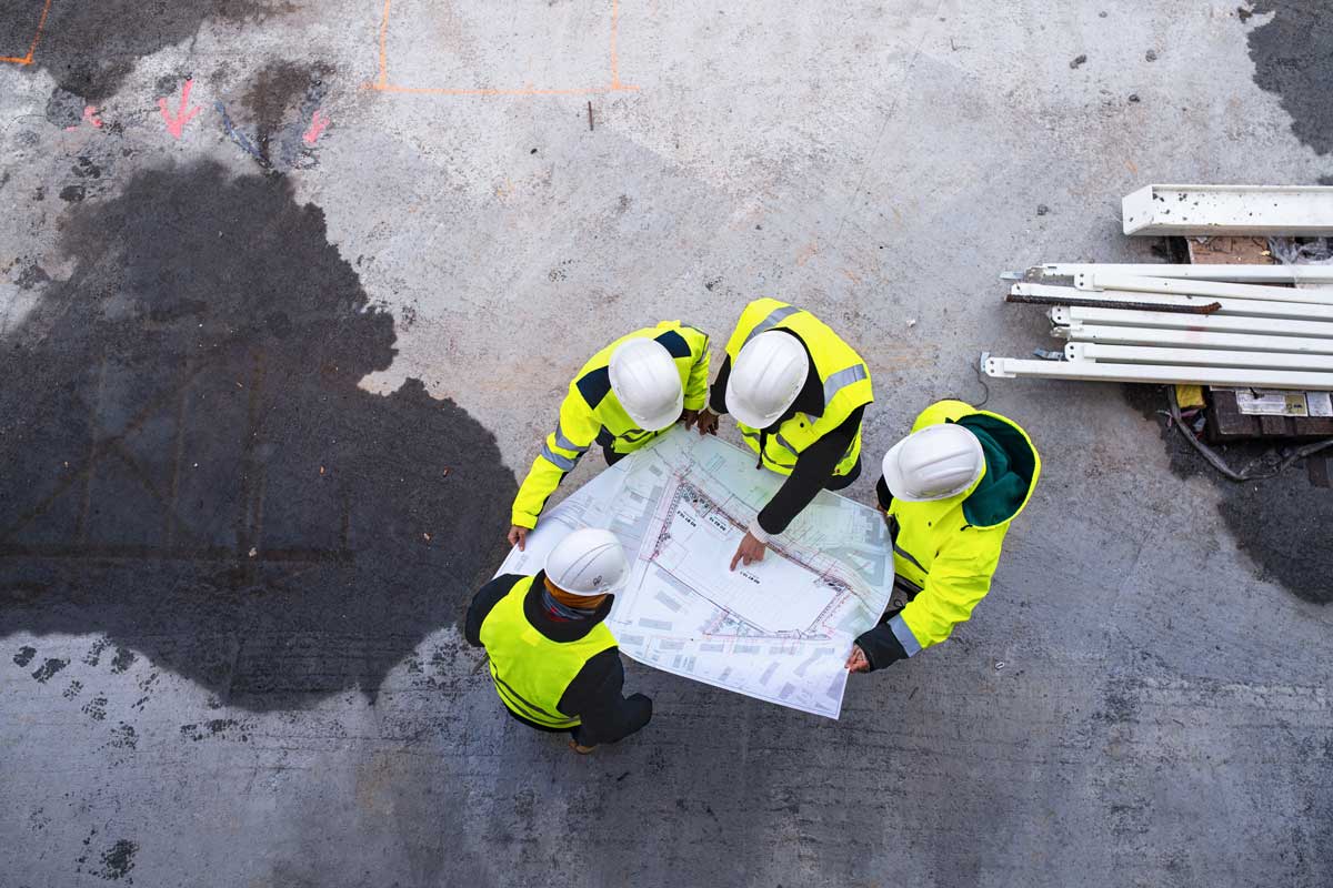 four construction workers referencing a paper map