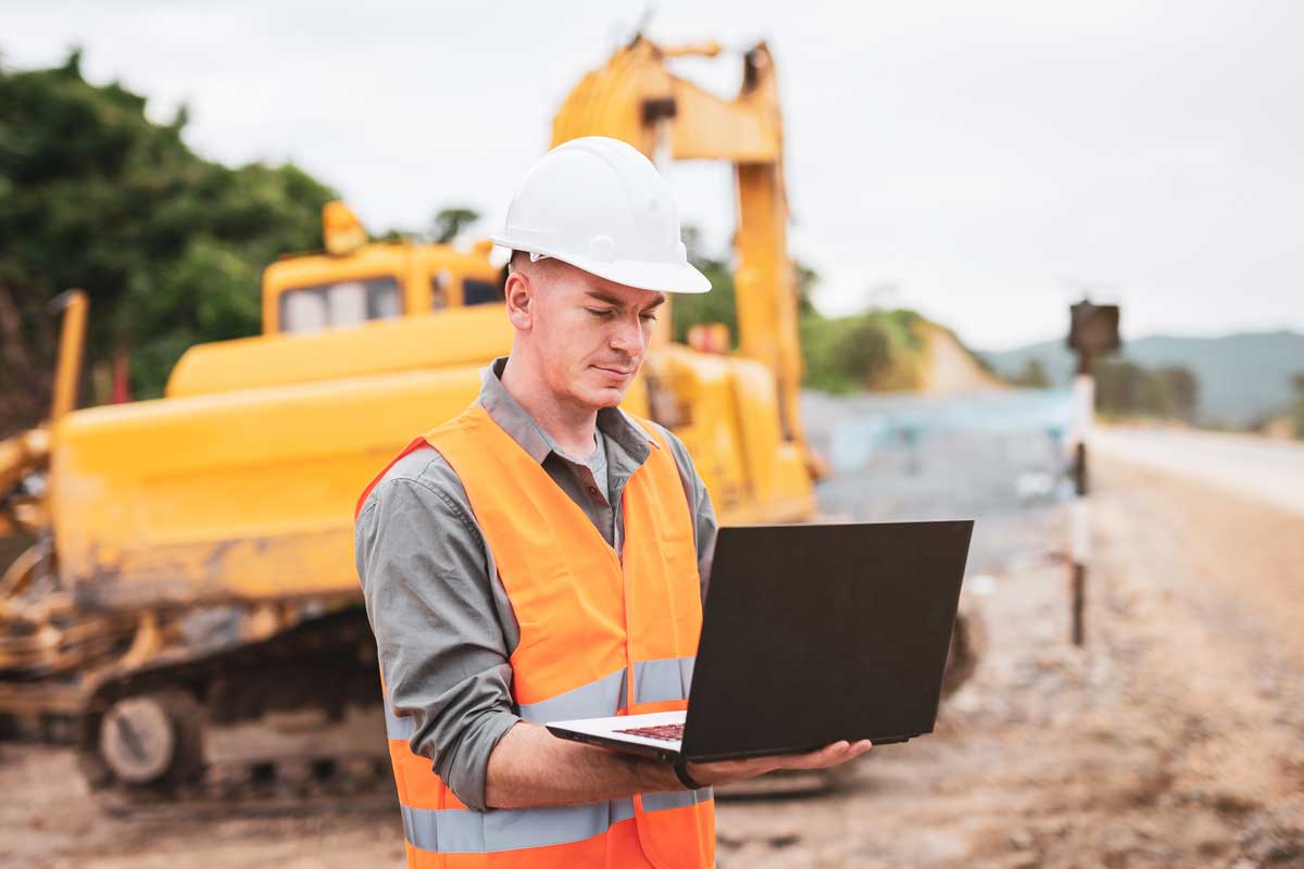 A construction worker in the field using data management tools