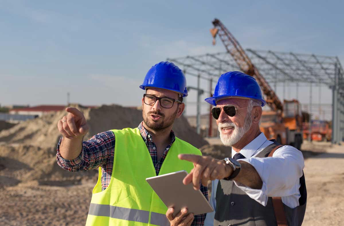 Construction team members on a jobsite use a digital map on a tablet.