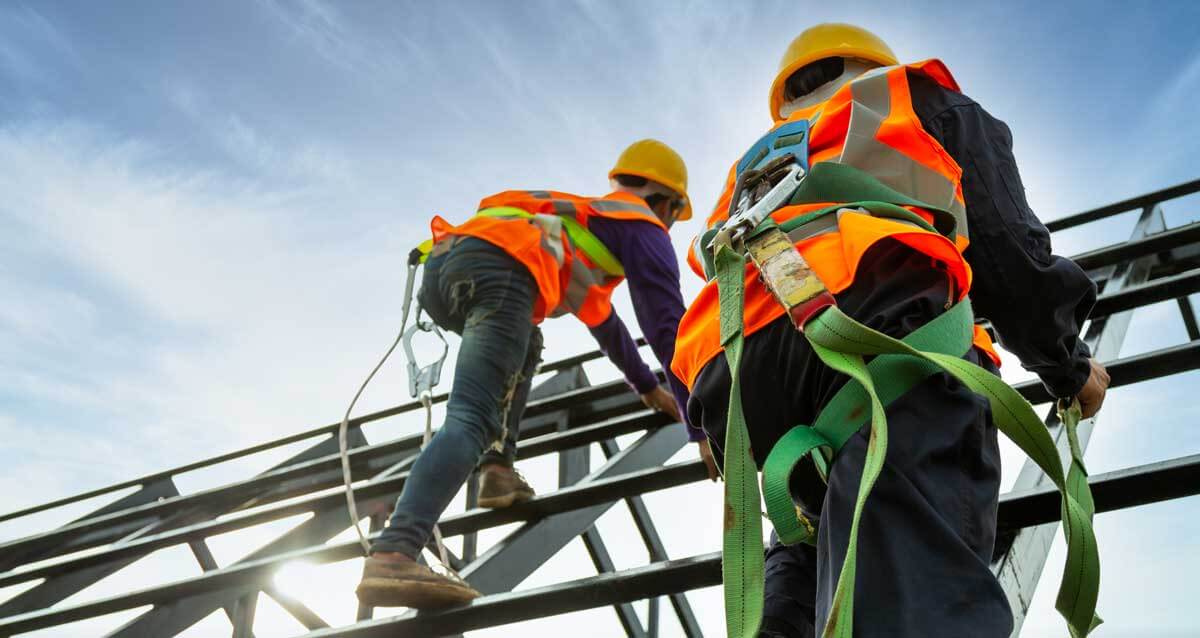 Construction workers climb scaffolding during a construction site safety inspection.