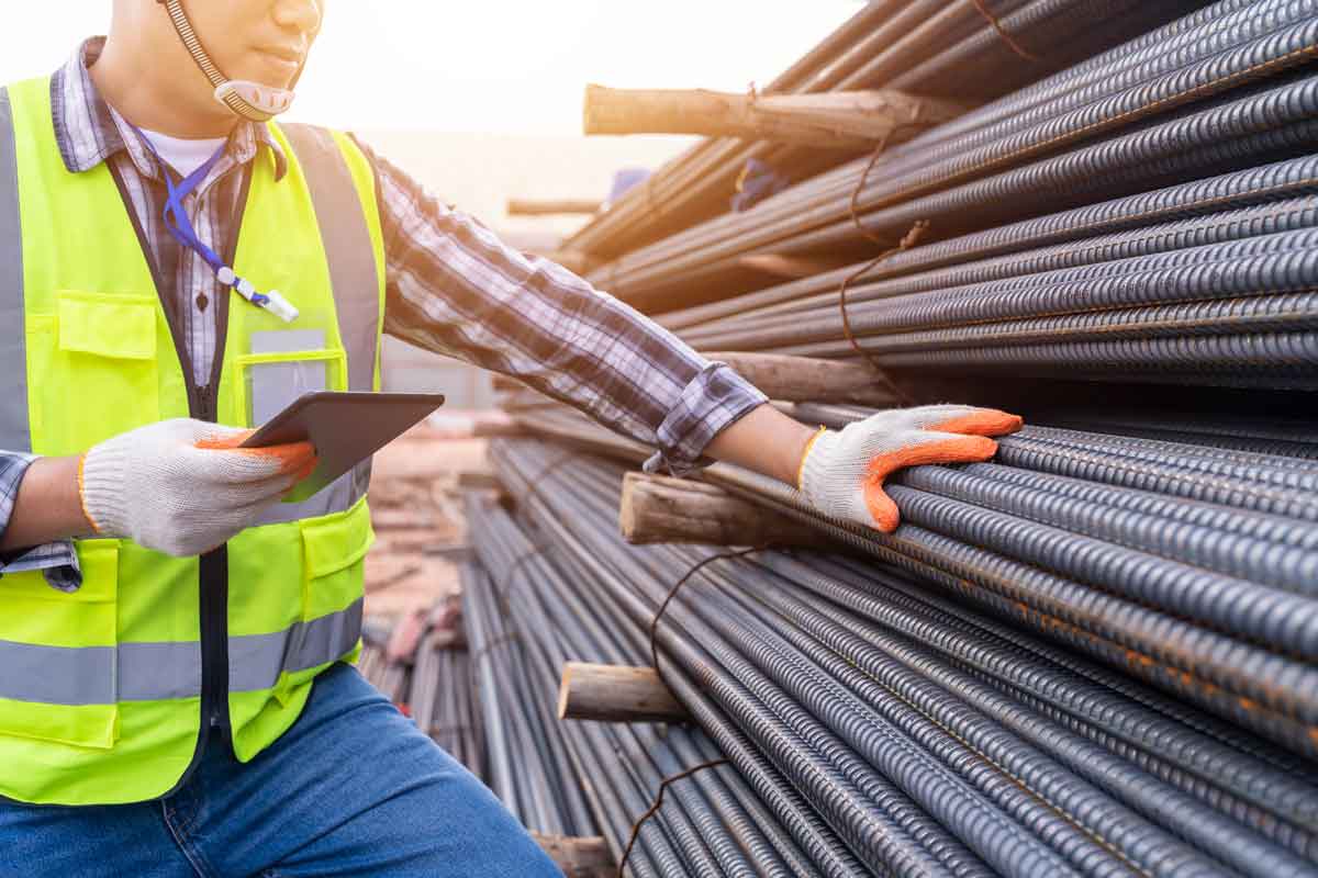 Construction worker touches rebar during a construction materials inspection.