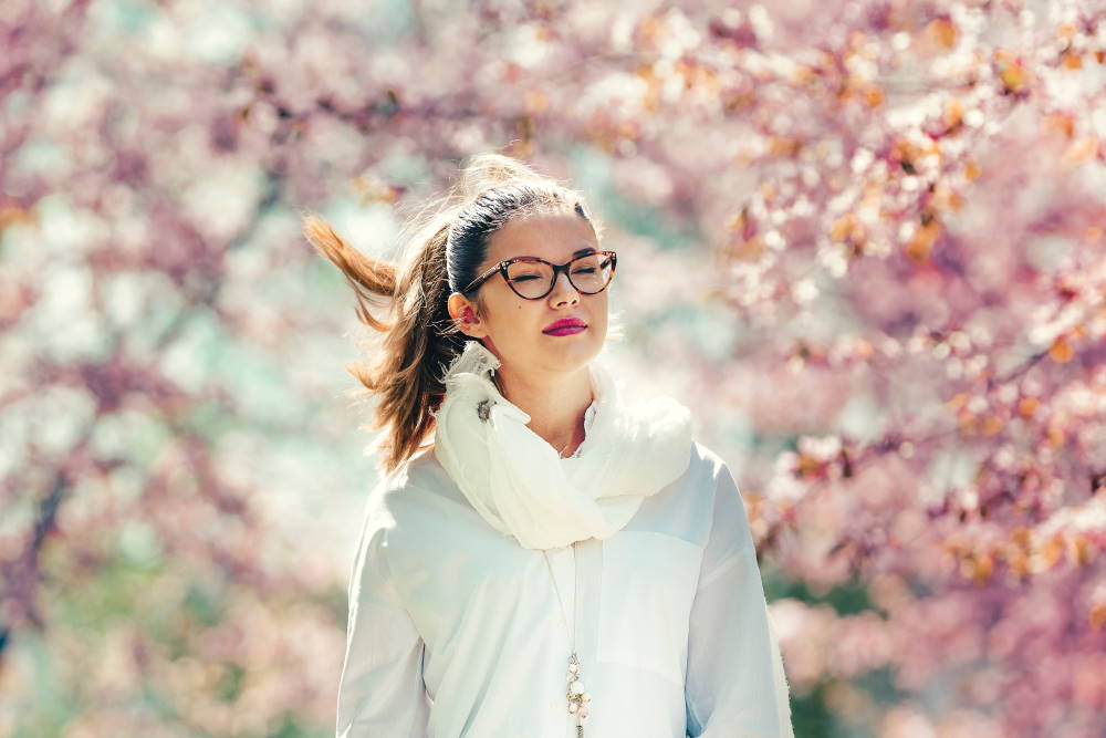 女性が桜の下を歩く