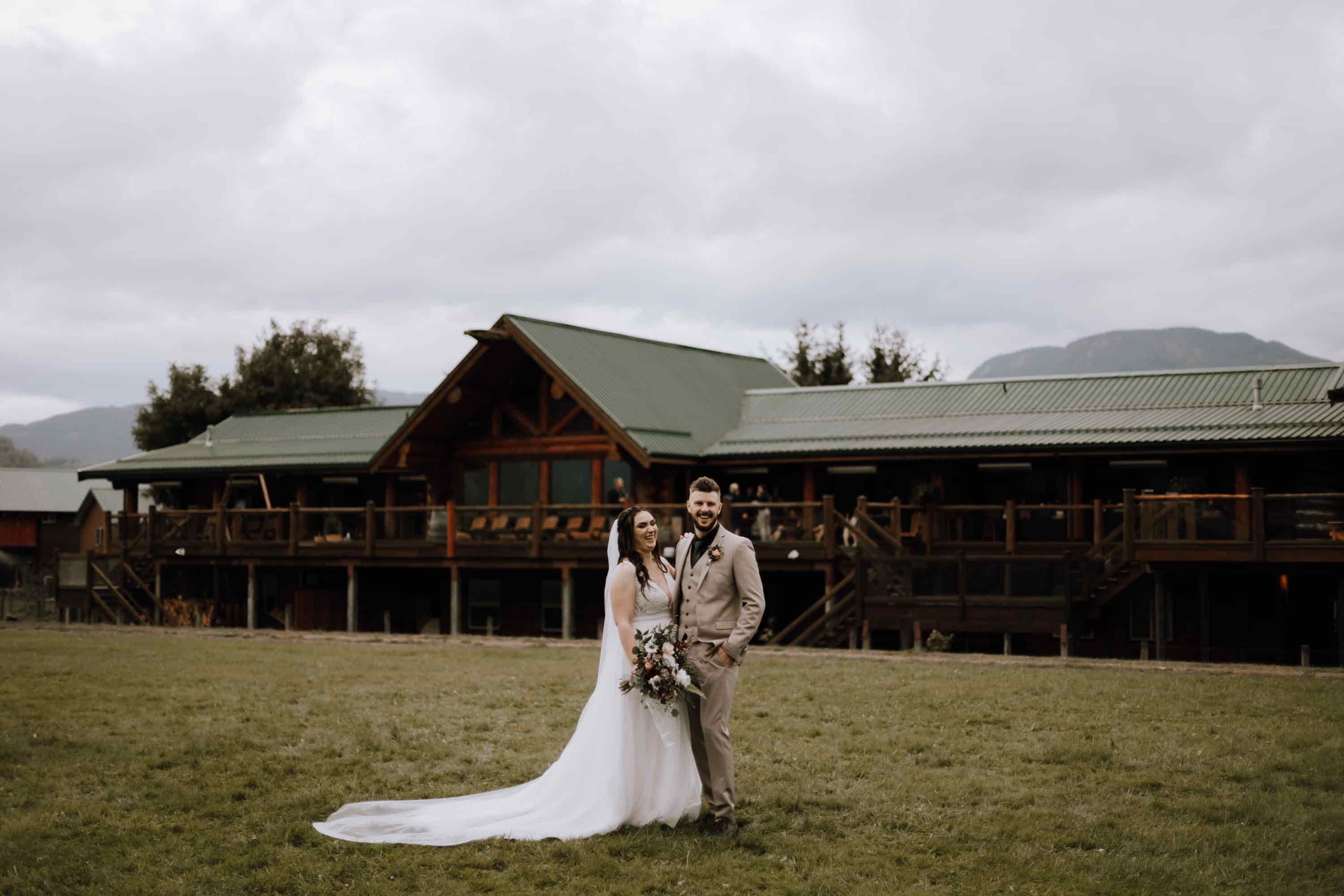 Bride and groom posing for photos in front of the Lodge