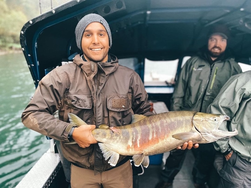 Fisher man displays a large salmon caught fishing on the Fraser river