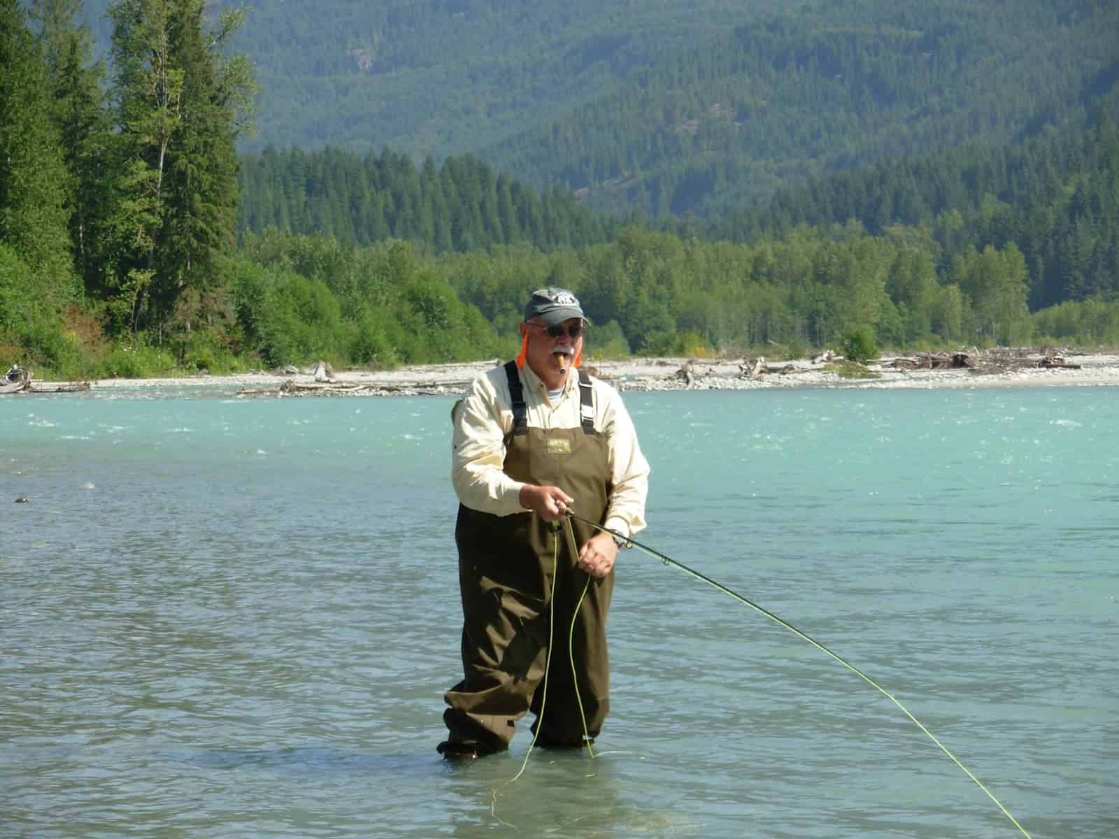 A man standing in the river with a fishing rod