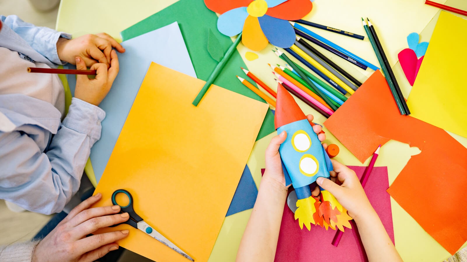 Two young children painting and creating sticker charts