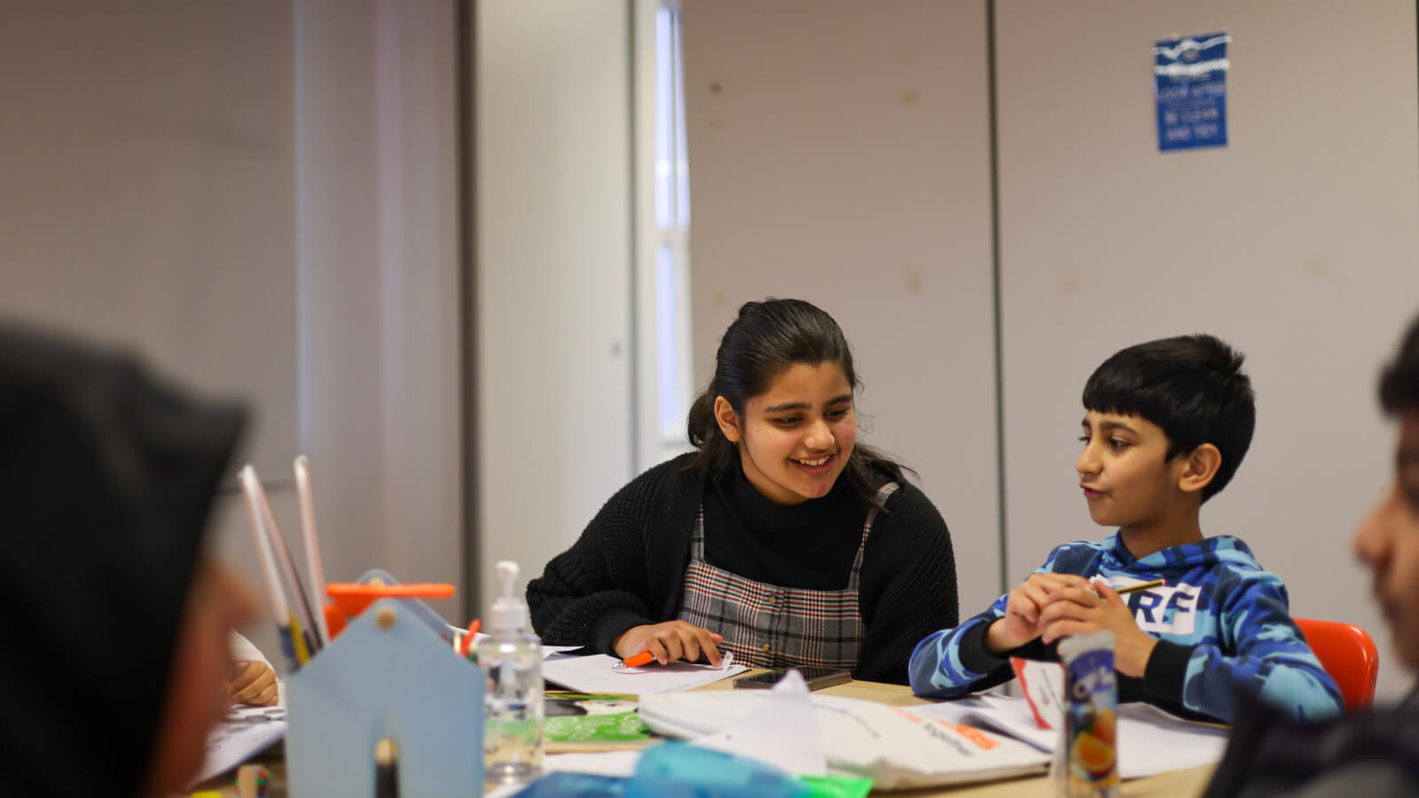 tutor at our Blackburn branch smiling and helping a student with maths work